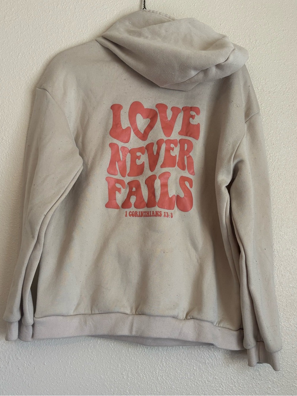 Women’s Cream Crewneck Hoodie with Orange 'Love Never Fails' Graphic